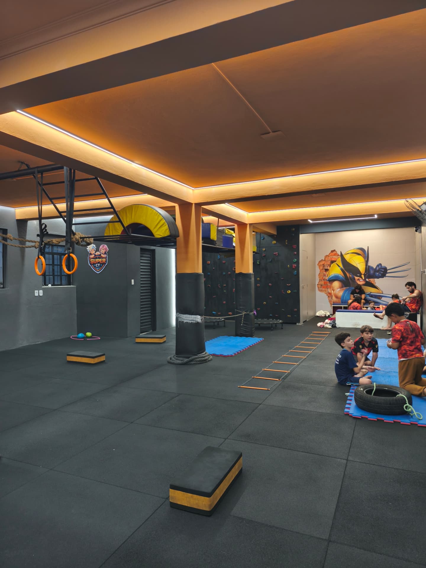 Área de treino do Super CT com piso emborrachado e iluminação laranja